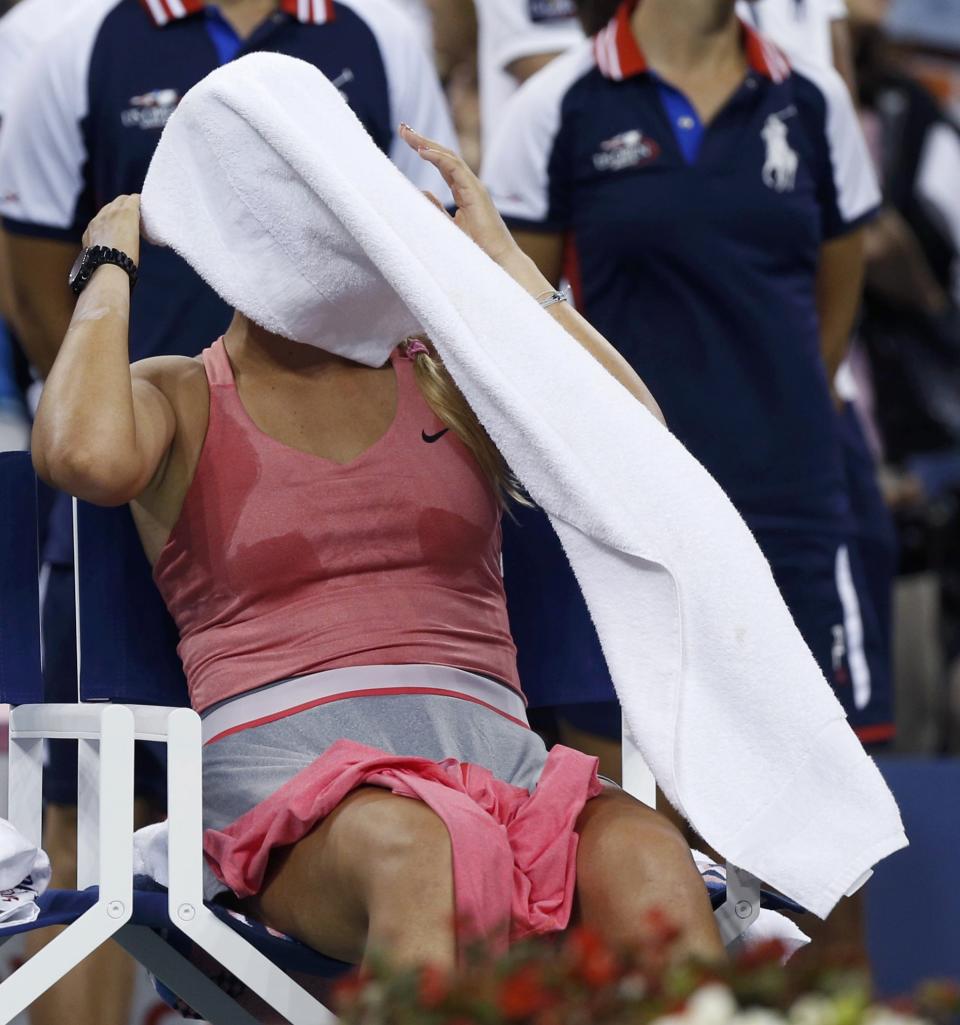 Azarenka of Belarus sits with a towel over her face after being defeated by Serena Williams of the U.S. in their women's singles final match at the U.S. Open tennis championships in New York