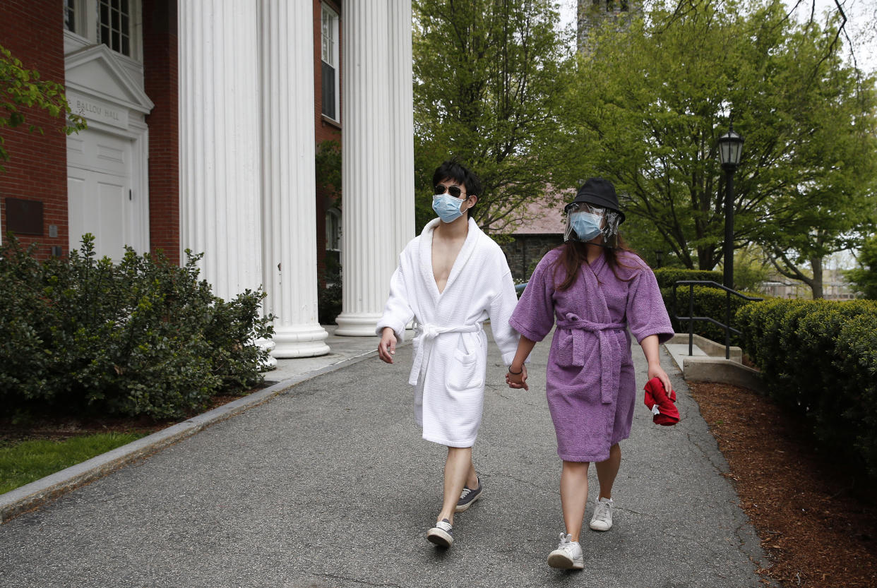 BOSTON, MA - MAY 17: Graduating Tufts Seniors Seungyoon Kim, left, and Georgette Koo walk on campus in Medford, MA on May 17, 2020. They had no reason to dress up today since their Commencement was cancelled due to COVID-19 so they strolled through campus in their bathrobes instead of a cap and gown. (Photo by Jessica Rinaldi/The Boston Globe via Getty Images)