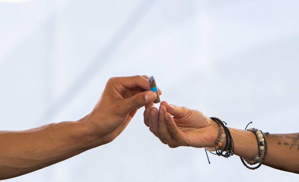 Michael Johnson, left, hands a prerolled joint to his mother, Caprice Lacy, in the cannabis consumption lounge on Tuesday during the California State Fair in Sacramento. “It’s such a chill vibe,” Johnson said. “It’s a pretty cool space to be in.”