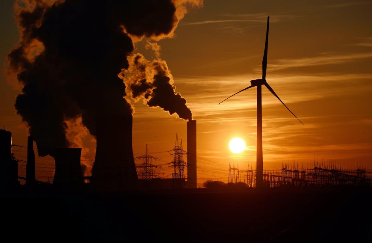 <span class="caption">The energy transition is already underway.</span> <span class="attribution"><a class="link " href="https://www.gettyimages.com/detail/news-photo/electricity-pylons-and-wind-turbines-stand-beside-the-rwe-news-photo/510814700" rel="nofollow noopener" target="_blank" data-ylk="slk:Volker Hartmann/Getty Images;elm:context_link;itc:0;sec:content-canvas">Volker Hartmann/Getty Images</a></span>