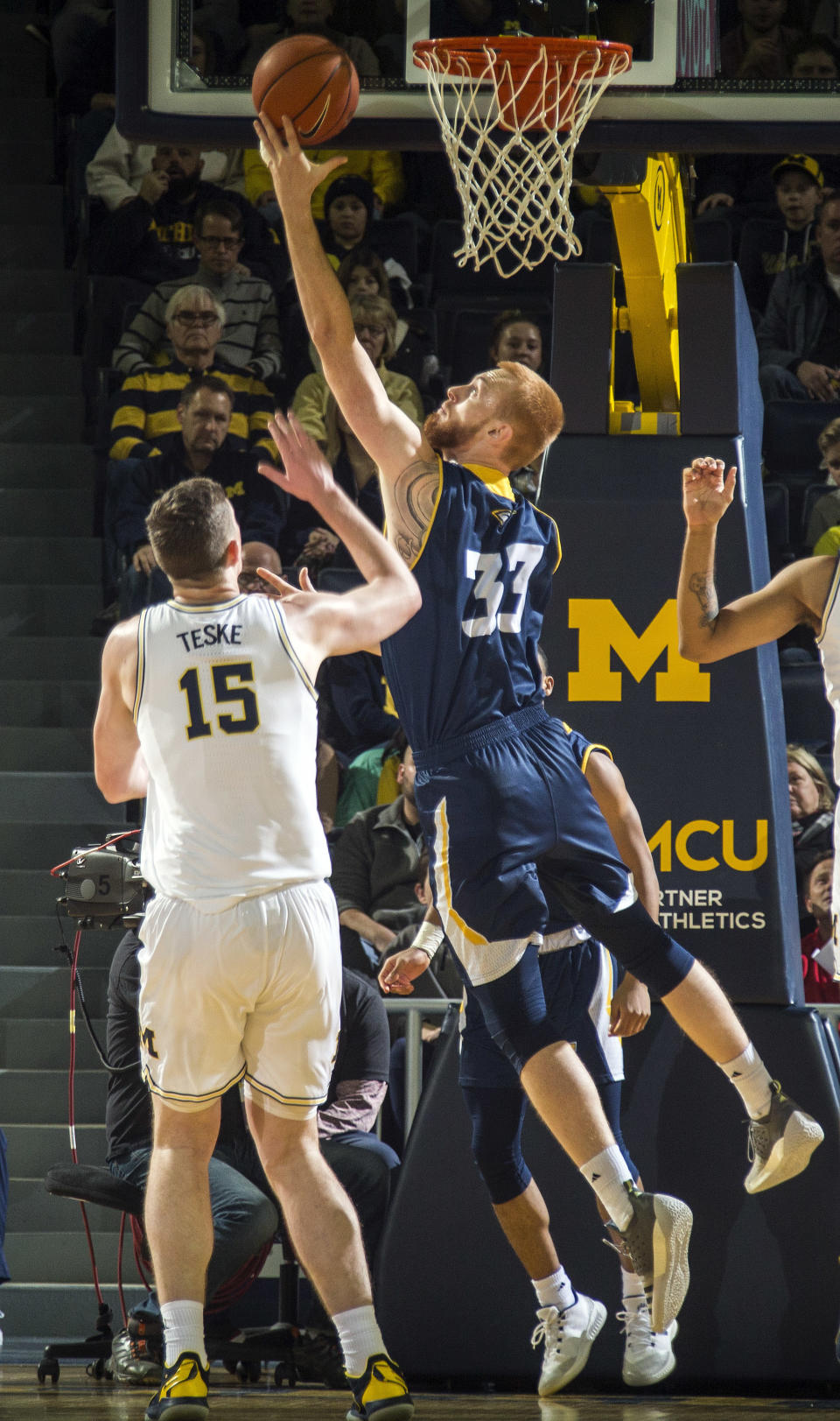 Chattanooga center Thomas Smallwood (33) makes a layup whiledefended by Michigan center Jon Teske (15) in the first half of an NCAA college basketball game at Crisler Center in Ann Arbor, Mich., Friday, Nov. 23, 2018. (AP Photo/Tony Ding)
