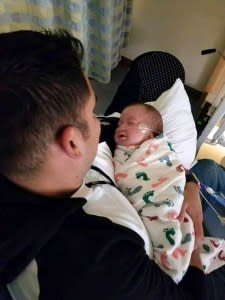 Officer Arturo Zepeda holds baby Axel