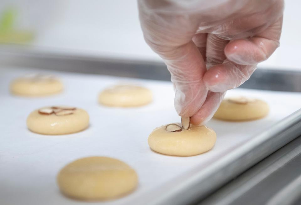 Liang Xu, owner of The Pretty Bear's Bakery, makes almond cookies in Pensacola on Thursday. Xu will be selling these cookies and other treats for the Lunar New Year at Gallery Night and at the Palafox Market in downtown Pensacola.