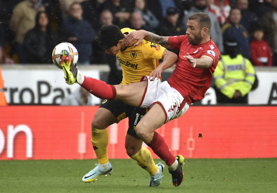 Nottingham Forest's Steve Cook, right, challenges for the ball with Wolverhampton Wanderers' Hwang Hee-chan during the English Premier League soccer match between Wolverhampton Wanderers and Nottingham Forest at Molineux stadium in Wolverhampton, England, Saturday, Oct. 15, 2022. (AP Photo/Rui Vieira)