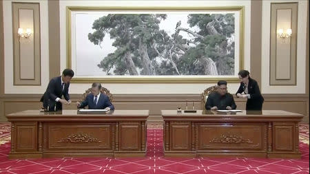 South Korean President Moon Jae-in and North Korean leader Kim Jong Un sign documents during the inter-Korean summit at the Paekhwawon State Guesthouse in Pyongyang, North Korea in this still frame taken from video September 19, 2018. KBS/via REUTERS TV