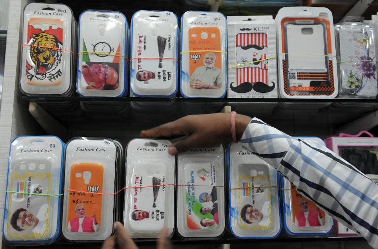 An Indian shopkeeper arranges freshly arrived snap-on mobile phone covers at his shop in Mumbai on April 2, 2014