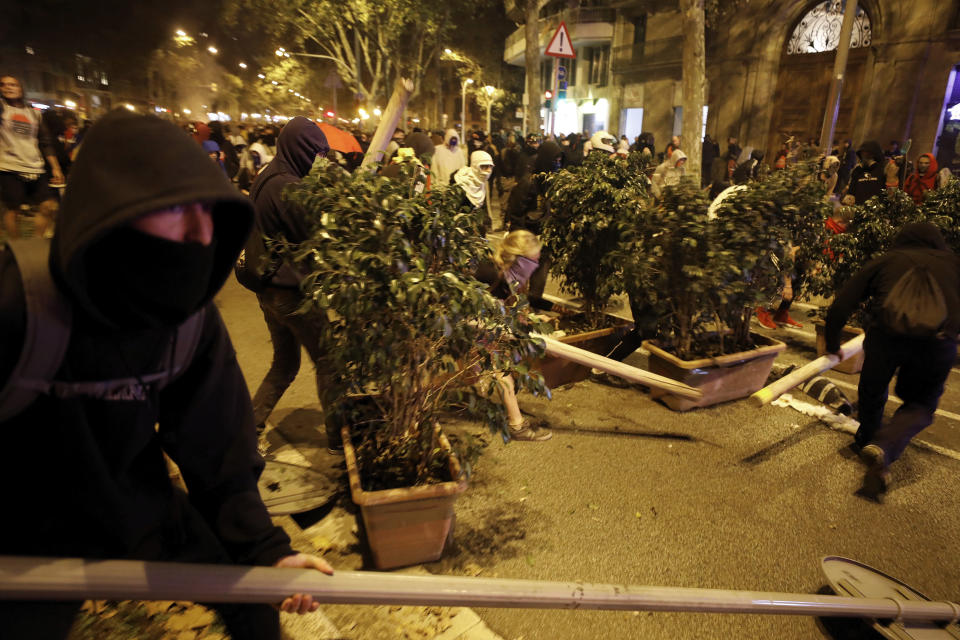 Protestors build barricades during clashes with police in Barcelona, Spain, Wednesday, Oct. 16, 2019. Spain's government said Wednesday it would do whatever it takes to stamp out violence in Catalonia, where clashes between regional independence supporters and police have injured more than 200 people in two days. (AP Photo/Emilio Morenatti)
