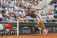 FILE - In this June 4, 2019, file photo, Switzerland's Roger Federer dives to return a shot in the third set against Switzerland's Stan Wawrinka during their quarterfinal match of the French Open tennis tournament at Roland Garros stadium in Paris. (AP Photo/Michel Euler, File)