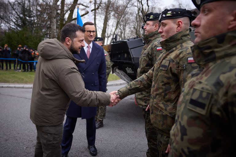 El presidente ucraniano, Volodimir Zelensky, saluda a soldados polacos acompañado por el primer ministro Mateusz Morawiecki, en Varsovia. (Ukrainian Presidency/dpa)