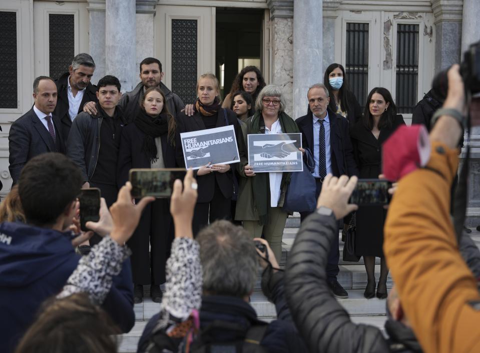 Protesters, laywyers and aid workers pose for the media outside a court in Mytilene, on the northeastern Aegean island of Lesbos, Greece, Friday, Jan. 13, 2023. The trial of 24 Greek and foreign aid workers and volunteers who participated in migrant rescue operations has drawn widespread criticism from international human rights groups. (AP Photo/Panagiotis Balaskas)