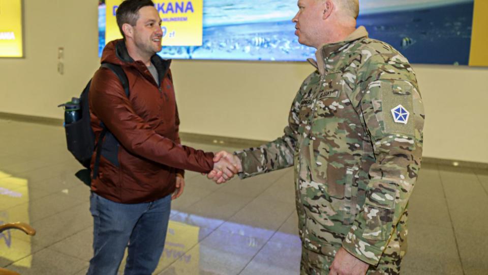 Command Sgt. Maj. Christopher A. Prosser, right, shakes the hand of Sgt. Walter Malecki, left, at the Poznan Airport, Feb. 10, 2022. (Spc. Devin Klecan/Army)