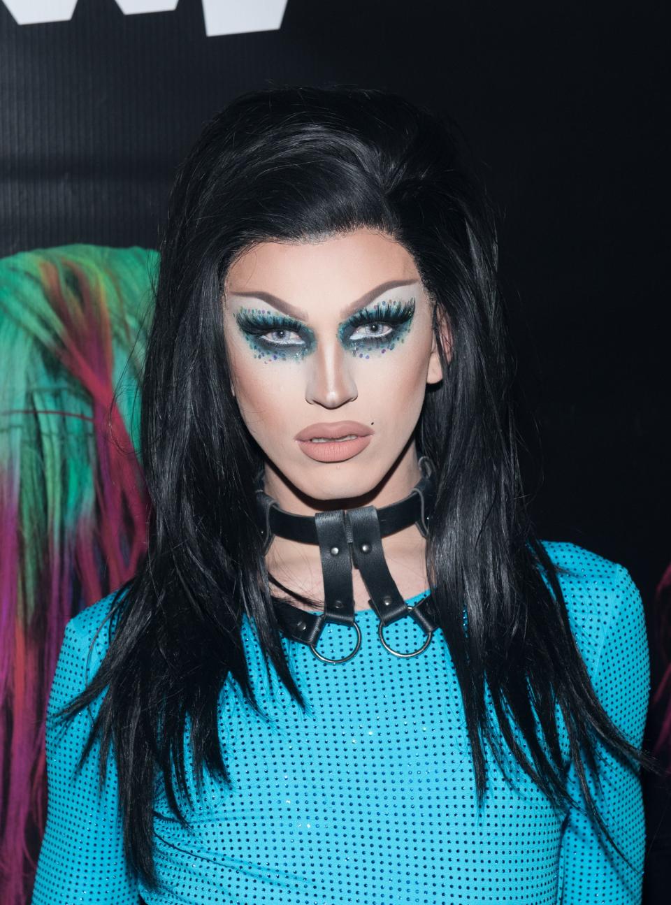 Aquaria wearing blue eyeshadow and a black choker necklace