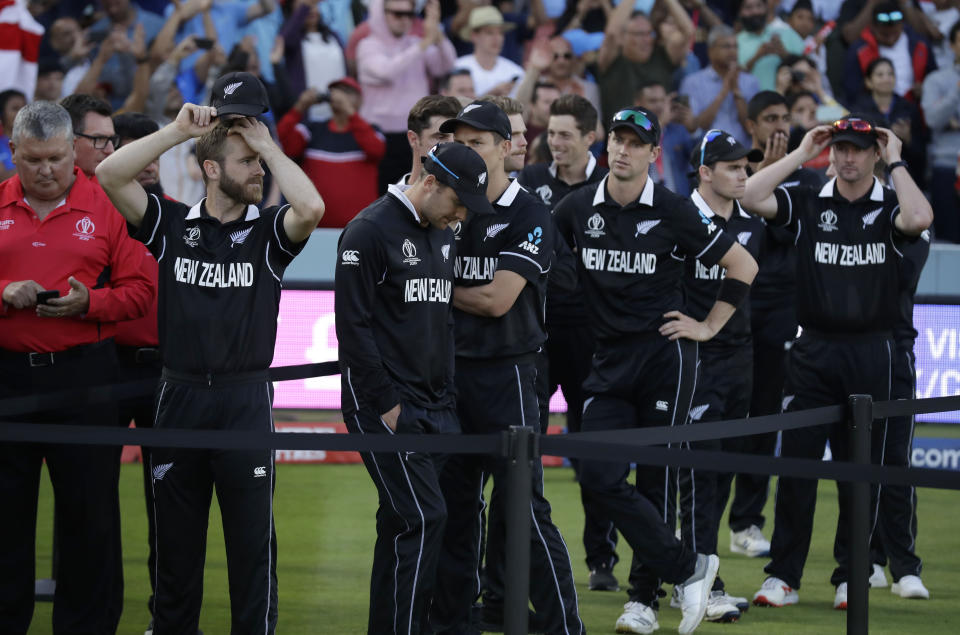 New Zealand's captain Kane Williamson, left, stands with his players as he waits for the trophy presentation after losing the Cricket World Cup final match between England and New Zealand at Lord's cricket ground in London, Sunday, July 14, 2019. England won after a super over after the scores ended tied after 50 overs each. (AP Photo/Matt Dunham)