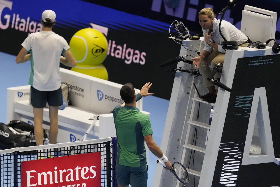 Serbia's Novak Djokovic, bottom, talks with referee during the singles tennis match against Italy's Jannik Sinner, of the ATP World Tour Finals at the Pala Alpitour, in Turin, Italy, Tuesday, Nov. 14, 2023. (AP Photo/Antonio Calanni)