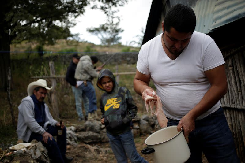 Members of the Ramirez family cook pork during a family meeting at their farm in Jalpan de Serra