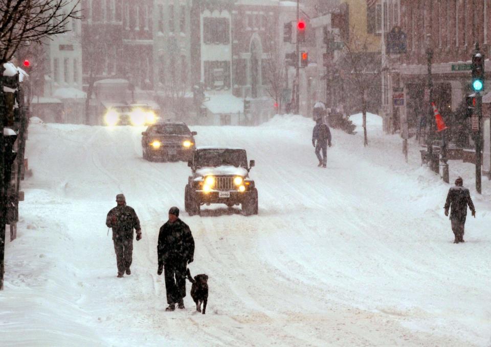 People and vehicles share Wisconsin Ave. during a snowstorm February 16, 2003 in Georgetown, Maryland.