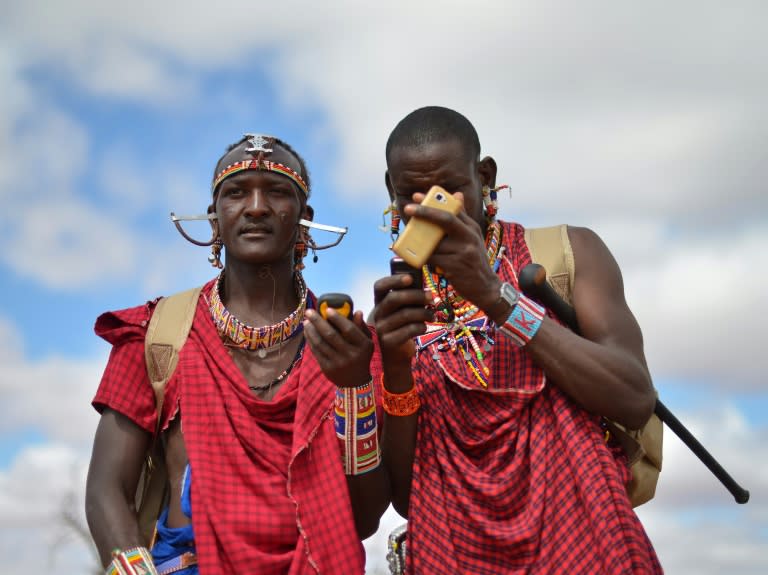 Kenyan Maasai 'Morans' (warriors) relay the GPS coordinates of the location of two-young lionesses they have been tracking on foot in the surrounding scrub, at the Selenkay Reserve, not far from Mount Kilimanjaro