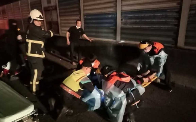 警消將被甩出車外的兩人趕緊送上救護車，可惜到院前，已經回天乏術。（圖／翻攝畫面）
