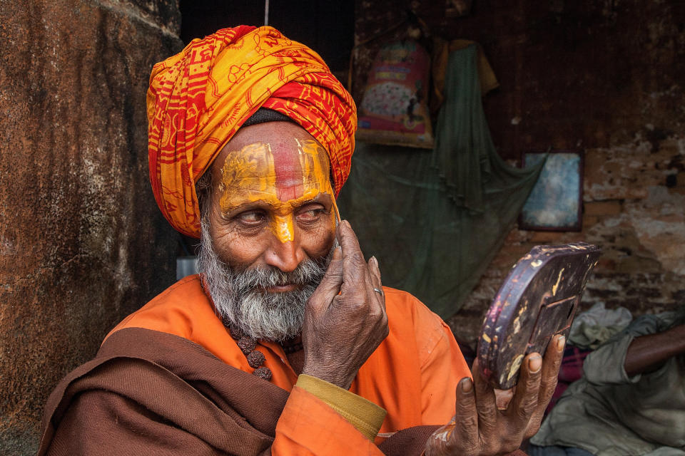 KATHMANDU, NEPAL - FEBRUARY 17:  A Shadu, or holy man, applies paint to his face inside Pashupatinath temple during the celebration of the Maha Shivaratri festival on February 17, 2015 in Kathmandu, Nepal. 