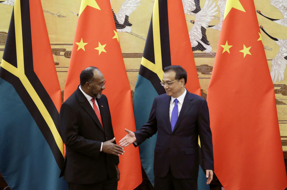 FILE - Vanuatu Prime Minister Charlot Salwai, left, and Chinese Premier Li Keqiang, right, shake hands at a signing ceremony at the Great Hall of the People in Beijing, China Monday, May 27, 2019. China wants 10 small Pacific nations to endorse a sweeping agreement covering everything from security to fisheries in what one leader warns is a “game-changing” bid by Beijing to wrest control of the region. (Jason Lee/Pool Photo via AP, File)