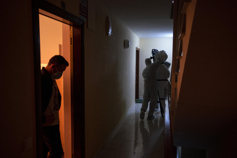 FILE - In this Dec. 23, 2020, file photo, mortuary workers remove the body of person who allegedly died of COVID-19 at her home in Barcelona, Spain. While most of Europe kicked off 2021 with earlier curfews or stay-at-home orders, authorities in Spain insist the new coronavirus variant causing havoc elsewhere is not to blame for a sharp resurgence of cases, and that the country can avoid a full lockdown even as its hospitals fill up. (AP Photo/Emilio Morenatti, File)