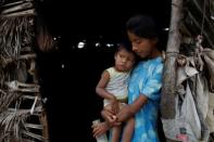 Aura Urdaneta (21), who suffers from chronic malnutrition, carries her child Josue Urdaneta (2) at her hovel in Paraguaipoa, Venezuela March 1, 2017. REUTERS/Marco Bello