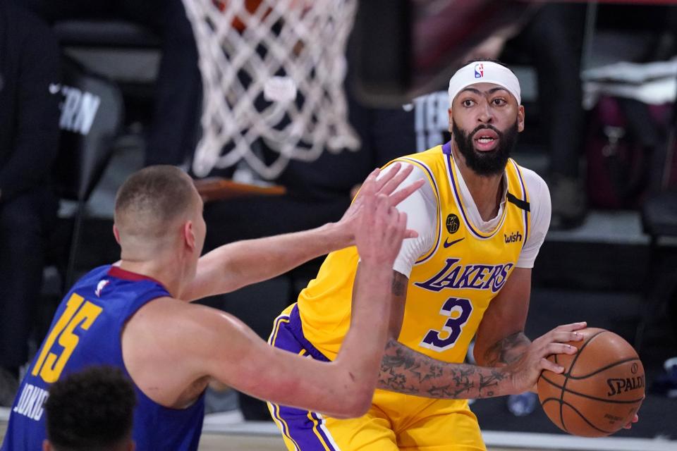 Denver Nuggets' Nikola Jokic (15) defends as Los Angeles Lakers forward Anthony Davis (3) looks for a shot opportunity during the second half an NBA conference final playoff basketball game, Friday, Sept. 18, 2020, in Lake Buena Vista, Fla. (AP Photo/Mark J. Terrill)