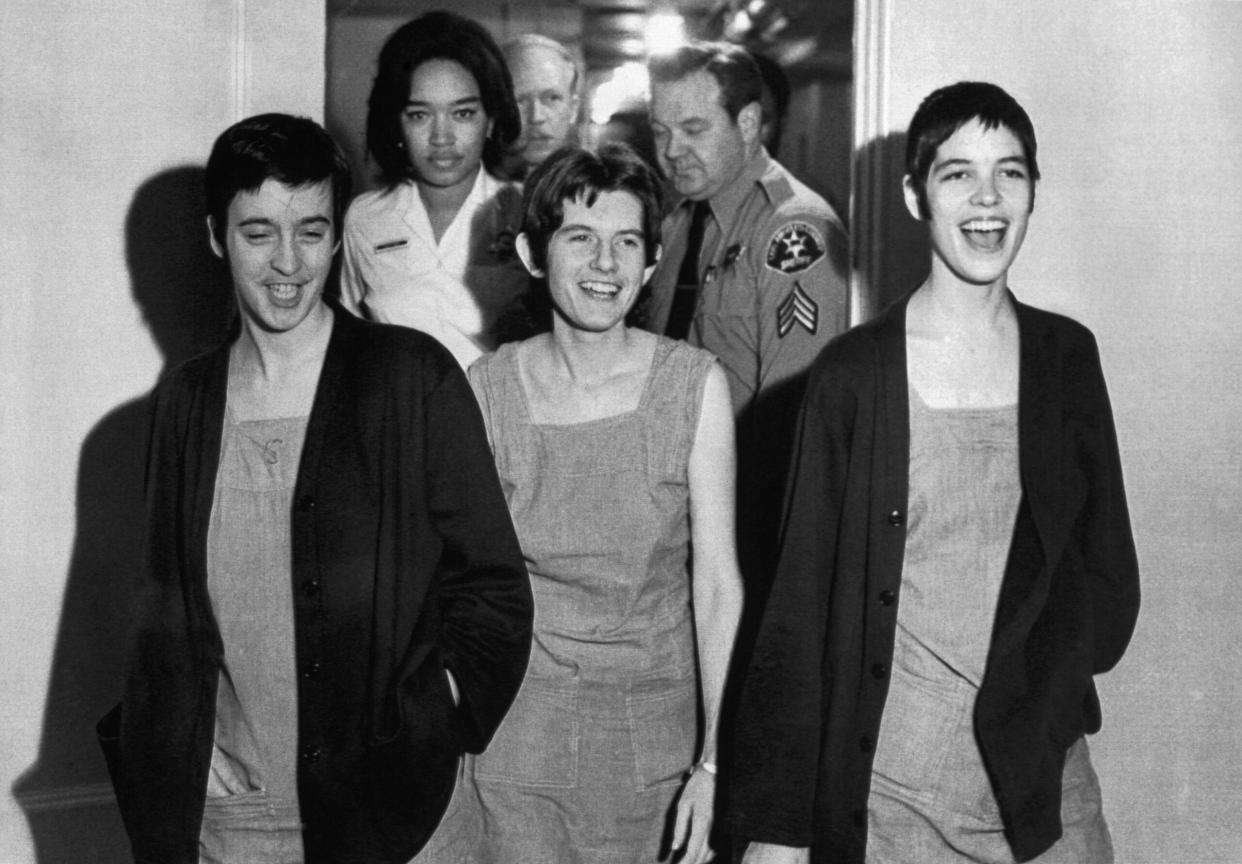 Leslie Van Houten (right) laughing after being sentenced to death for murders committed to provoke race war. Comrades Susan Denise Atkins (left), and Patricia Krenwinkel (center) were likewise condemned in 1971. Their death sentences were later commuted, and Van Houten is now free. (Credit: Getty Images)