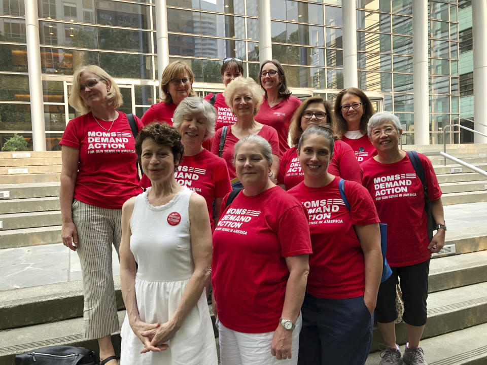 Members of the Washington Chapter of Moms Demand Action pose for a photo outside the federal courthouse in Seattle, Wash., Tuesday, Aug. 21, 2018, after attending a hearing to support the issuance of an injunction to block the online release of plans for printing 3D guns. A federal judge hearing arguments over whether the Trump administration should be allowed to maintain a settlement with a company that wants to post online plans for printing 3D guns said Tuesday that the issue should be decided by the president or Congress. (AP Photo/Martha Bellisle)