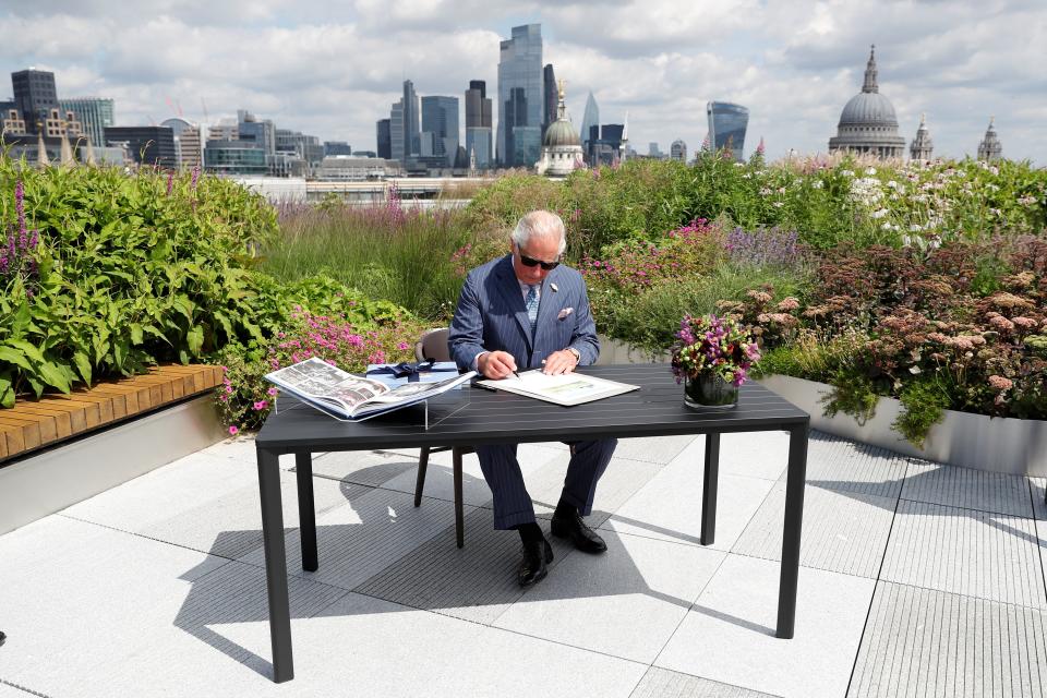 The Prince of Wales signs a document commemorating his visit to Goldman Sachs in central London (PA Wire)