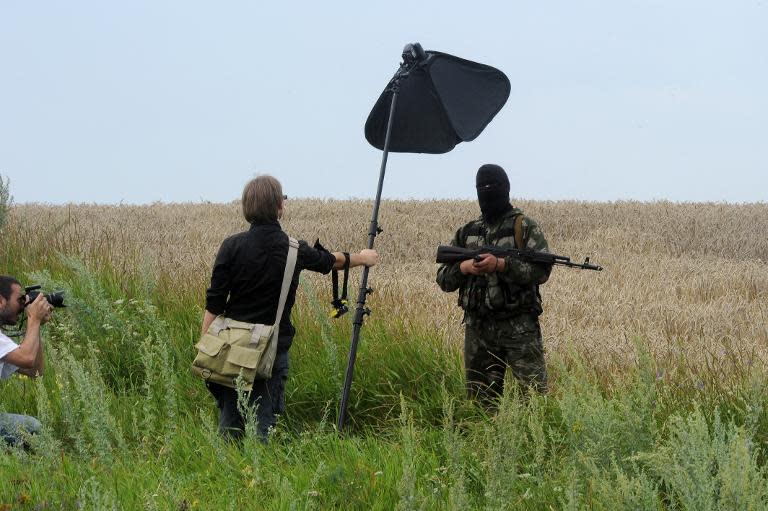 A masked armed separatist militant poses for a photographer near the site of the MH17 plane crash in eastern Ukraine, on July 19, 2014