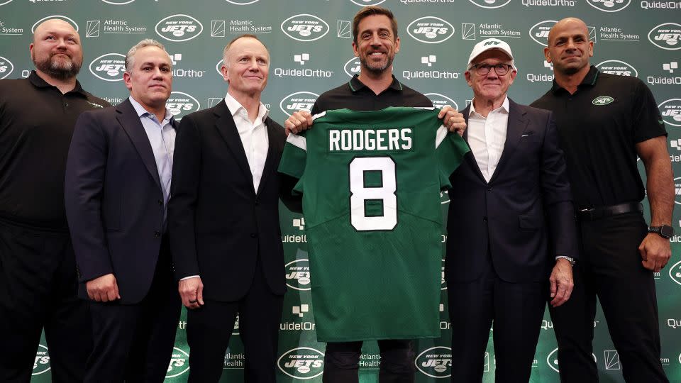 Rodgers poses with Jets general manager Joe Douglas, team president Hymie Elhai, team owner Christopher Johnson, team owner Woody Johnson and head coach Robert Saleh during his introductory press conference. - Elsa/Getty Images