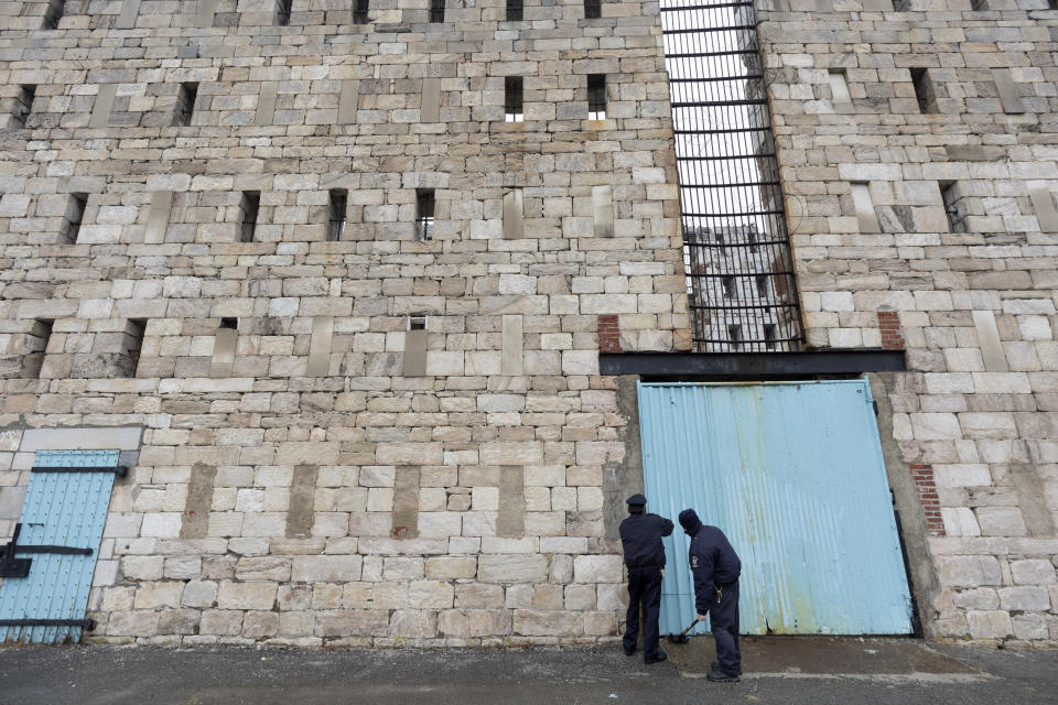 In this Feb. 13, 2020 photo, prison employees open a door to a former cell block at Sing Sing Correctional Facility in Ossining, N.Y. A museum is being planned with a unique feature: a 300-foot-long corridor connecting to the roofless ruins of the original 19th century cell block inside the prison. Museum-goers would stand at the site of the first cramped cells at the prison just "up the river" from New York City. (AP Photo/Mark Lennihan)