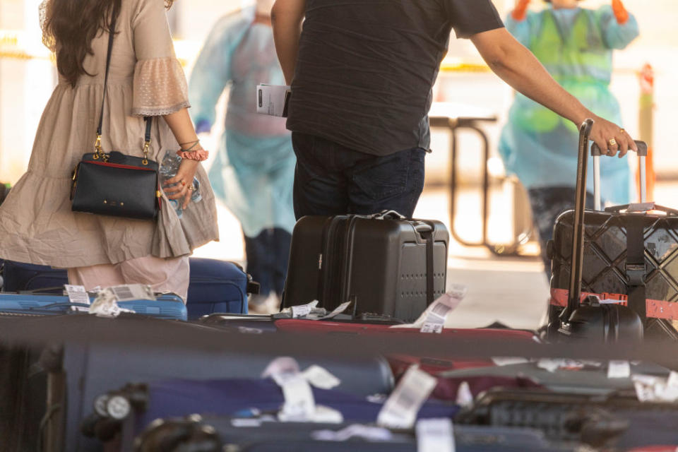 Aussie expatriates collect luggage from their Delhi flight. Source: Getty