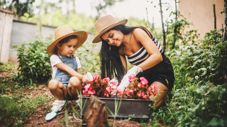 Mother And Daughter Working In The Garden.