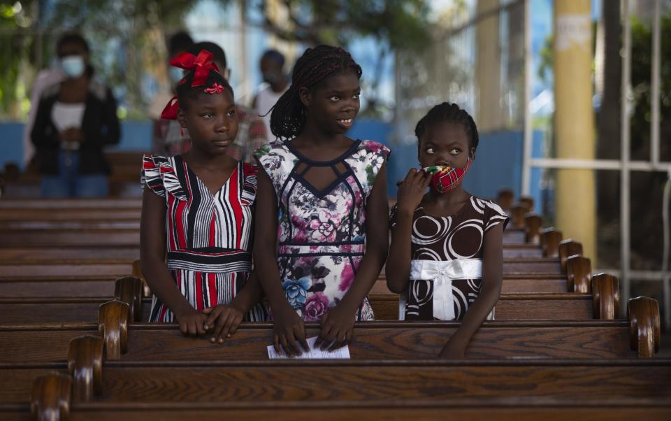 Firls attend Sunday Mass at Sacre-Coeur church, in Port-au-Prince, Sunday, July 11, 2021. four days after President Jovenel Moise was assassinated in his home. (AP Photo/Joseph Odelyn)