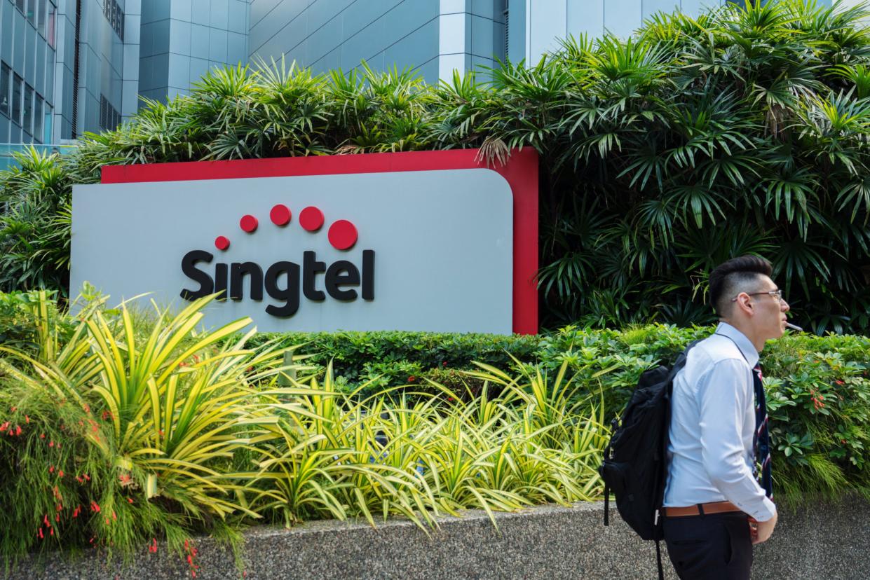 A man walks past signage for Singapore Telecommunications Ltd. (Singtel) in Singapore, on Friday, July 6, 2018.