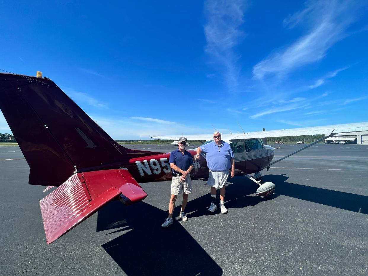 Rich Largent and Greg Vaughn stand in front of Largent's airplane at Cape Fear Regional Jetport in Oak Island.