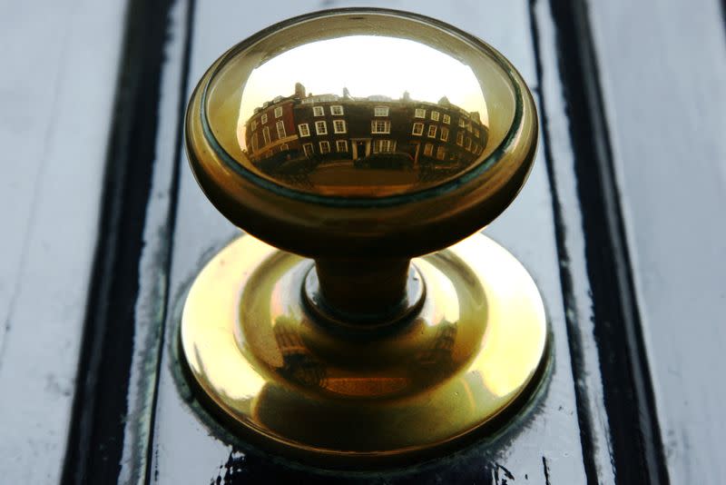FILE PHOTO: Houses are reflected in the door handle of a property in central London