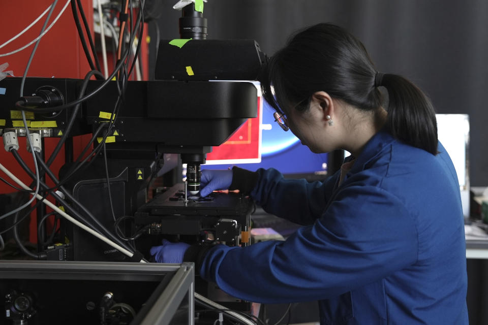 Naixin Qian, a Columbia physical chemist, demonstrates the placement of a sample for nanoplastics, microscopic plastic pieces, in New York on Monday, Jan. 8, 2024. A new study found the average liter of bottled water has nearly a quarter million invisible pieces of nanoplastics, detected and categorized for the first time by a microscope. (AP Photo/Mary Conlon)