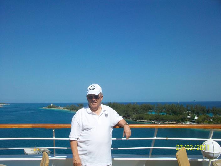 robert l willett posing for a photo on the deck of a cruise ship in front of blu skies