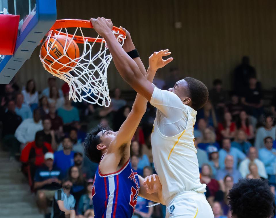 Stony Point forward Josiah Moseley scores on a leaping slam dunk over Westlake guard Max Purushothaman during the fourth quarter of Tuesday night's 49-35 win at the Burger Center. The Tigers advanced to the Class 6A regional tournament.