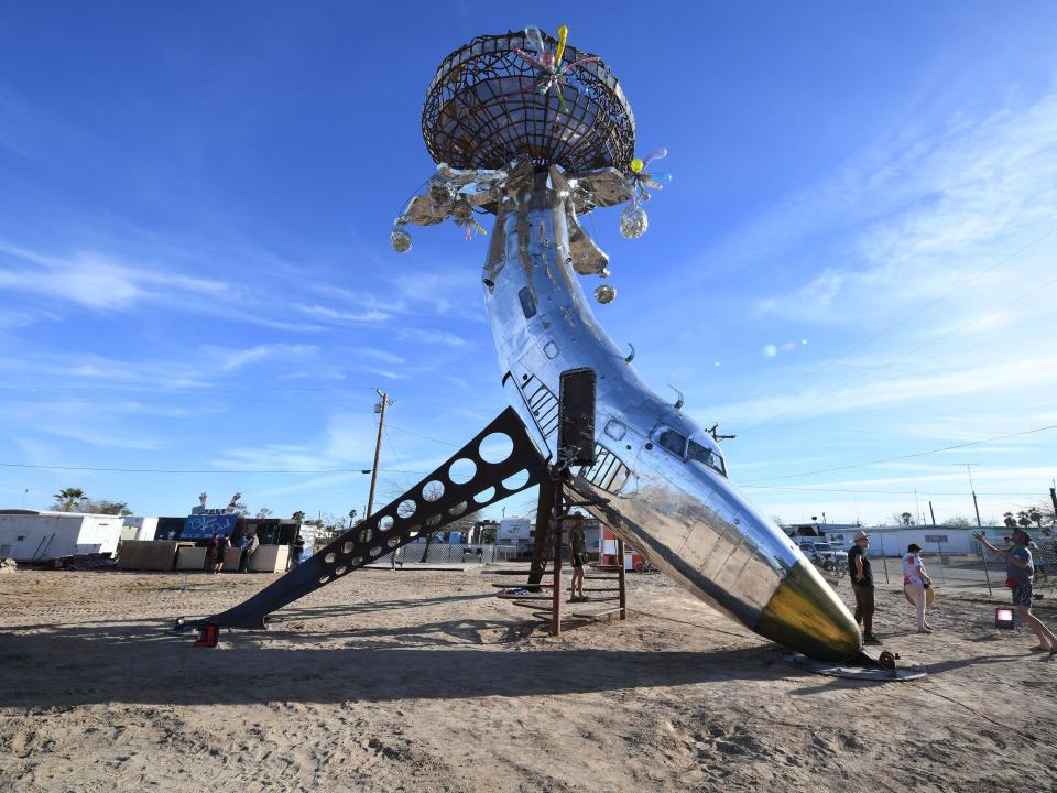 People visit an installation sculpture of a crashed plane by artist Randy Polumbo, on the first day of the Bombay Beach Biennale in 2019.