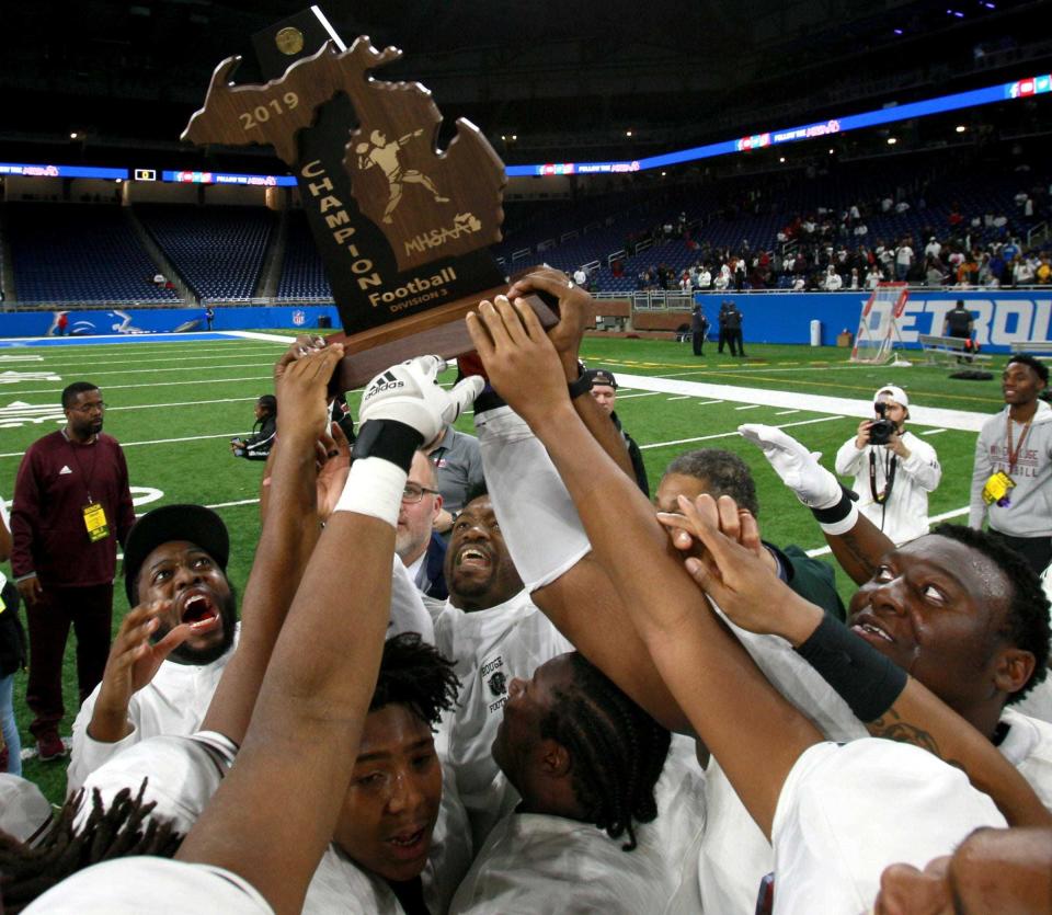 River Rouge celebrates with their first state championship trophy after winning the Division 3 state championship football game 30-7 against Muskegon at Ford Field on Saturday, November 30, 2019.