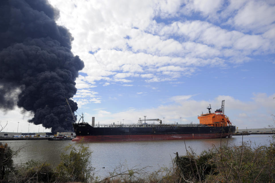 A tanker sails past a warehouse fire at the Georgia Ports Authority Ocean Terminal that firefighters are battling to contain in Savannah, Ga. on Saturday, Feb. 8, 2014. A Georgia Ports Authority spokesman said all port workers were safe and accounted for after the fire broke out. (AP Photo/Stephen B. Morton)