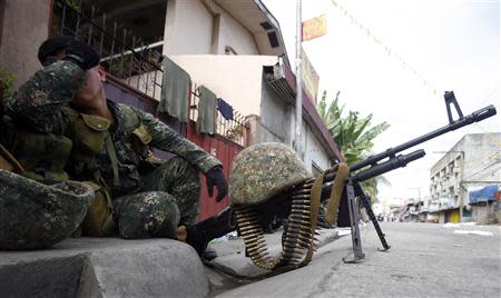 A member of Philippine Marines rests while guarding a road intersection on the fourth day of a government stand-off with the Moro National Liberation Front (MNLF) rebels in downtown Zamboanga city in southern Philippines, September 12, 2013. REUTERS/Erik De Castro