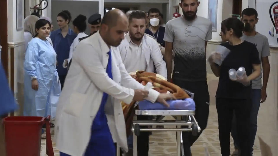 Esta imagen tomada de un video muestra personal médico llevando a una persona en un hospital en Hamdaniya, en la provincia de Nineveh, Irak, el miércoles 27 de septiembre de 2023. Un gran incendio aparentemente provocado por fuegos artificiales para celebrar una boda cristiana arrasó un salón lleno de invitados en el norte de Irak, donde mató a varias personas e hirió a otras, según las autoridades. (AP Foto)