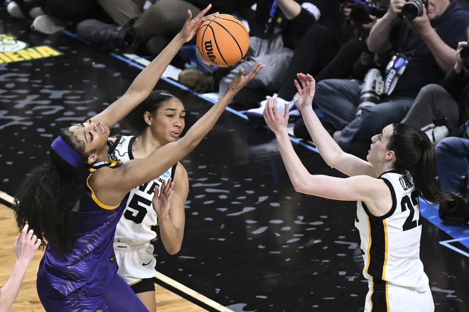 LSU forward Angel Reese (10) battles for a rebound against Iowa forward Hannah Stuelke (45) and guard Caitlin Clark (22) during the second half of an Elite Eight round college basketball game during the NCAA Tournament, Monday, April 1, 2024, in Albany, N.Y. (AP Photo/Hans Pennink)