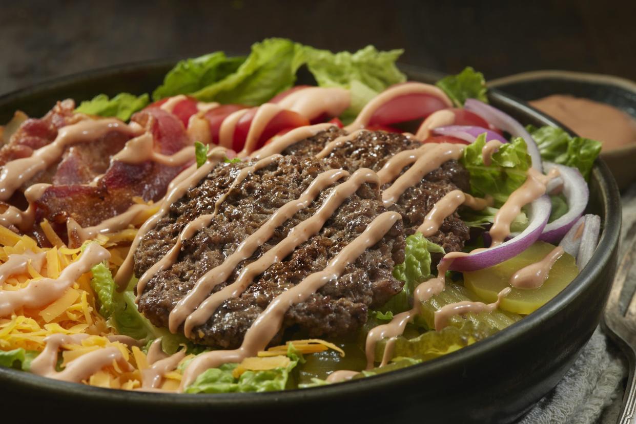 Bacon Double Cheeseburger Salad Bowl with Tomatoes, Lettuce, Red Onions, Pickles and Thousand Island Dressing