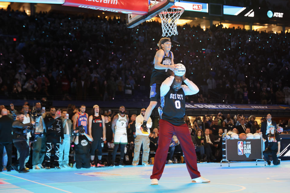 INDIANAPOLIS, INDIANA - FEBRUARY 17: Mac McClung #0 of the Osceola Magic dunks the ball over Shaquille O'Neal in the 2024 AT&T Slam Dunk contest during the State Farm All-Star Saturday Night at Lucas Oil Stadium on February 17, 2024 in Indianapolis, Indiana. NOTE TO USER: User expressly acknowledges and agrees that, by downloading and or using this photograph, User is consenting to the terms and conditions of the Getty Images License Agreement. (Photo by Stacy Revere/Getty Images)